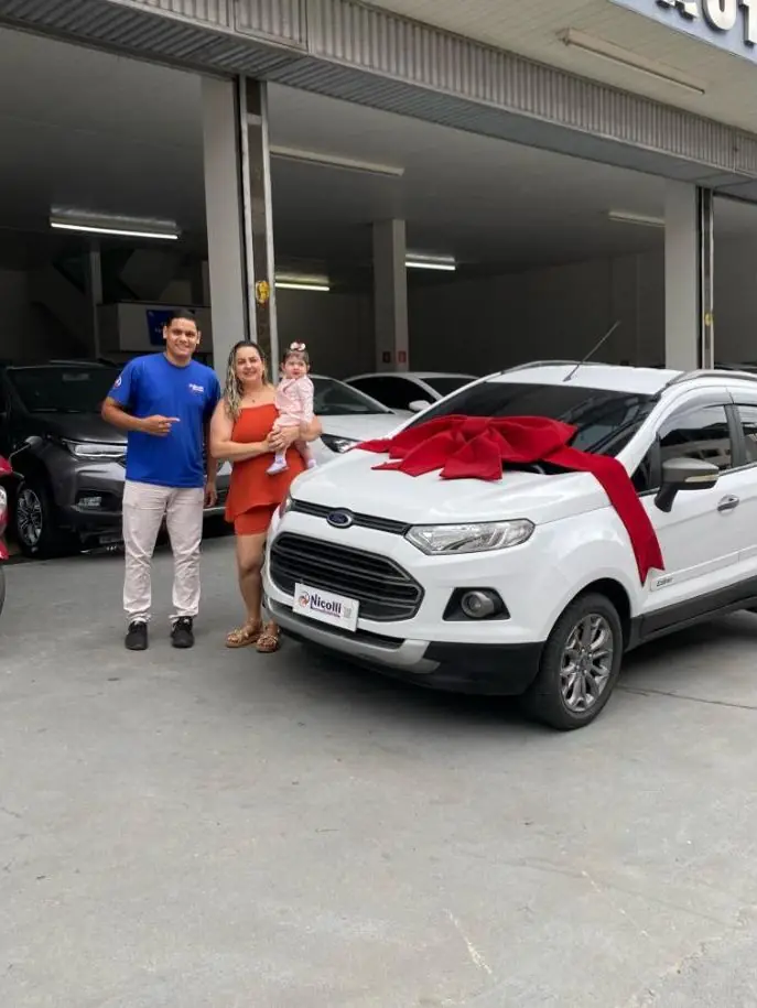 Lucas com mãe e bebê ao lado de um Ford EcoSport com laço